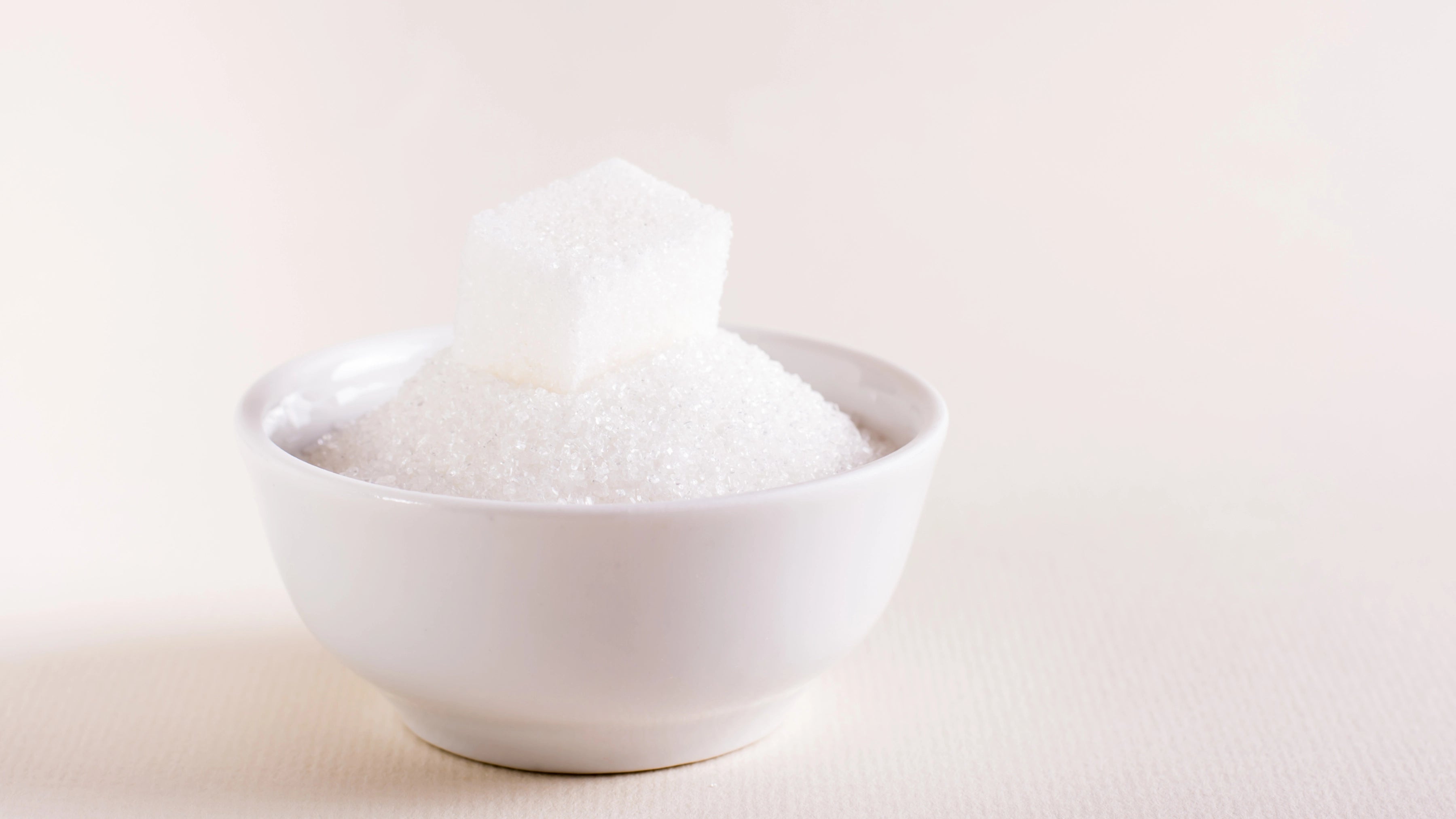 Sugar cubes in white bowl on the table