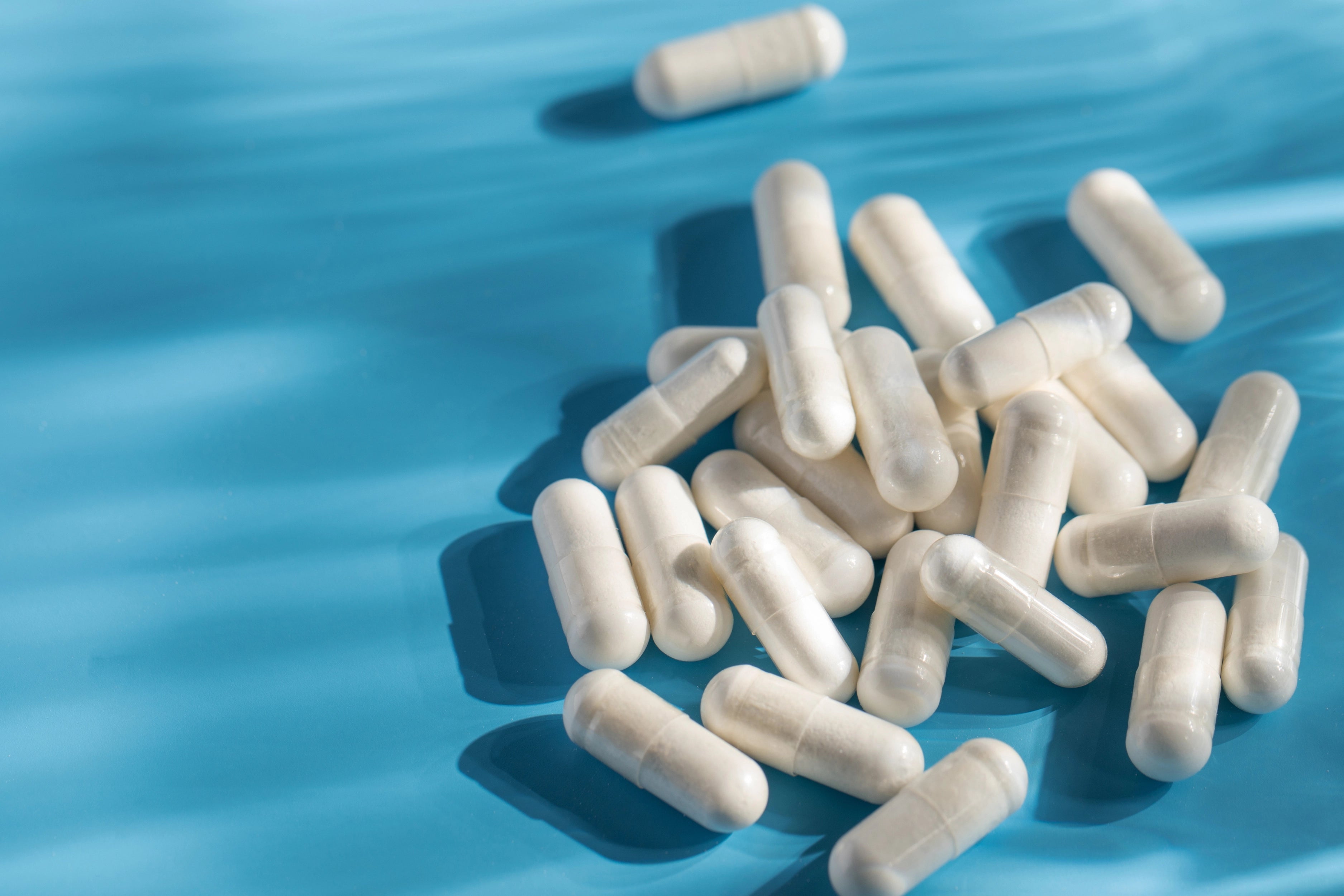 A woman holding 2 dietary supplement pills in her palm